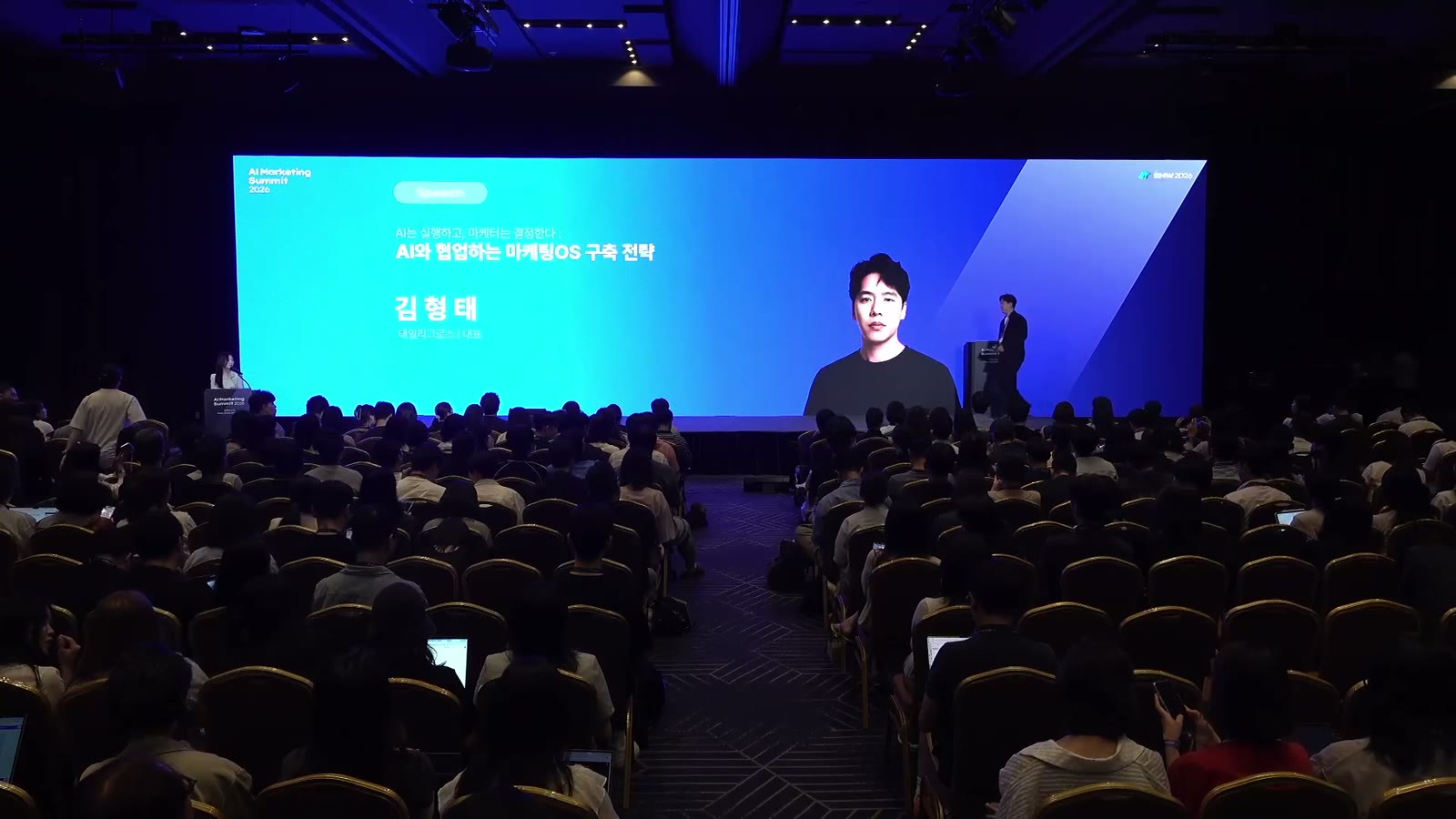AI Marketing Summit 2026 무대에서 발표하는 김형태 데일리그로스 대표와 가득 찬 객석